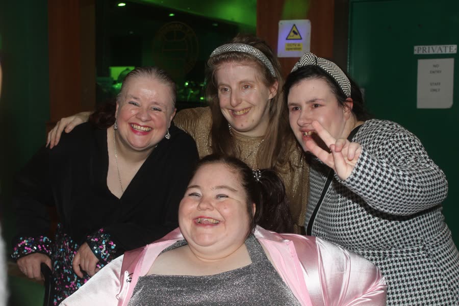 Four members dressed up and smiling together at a Big Night Out